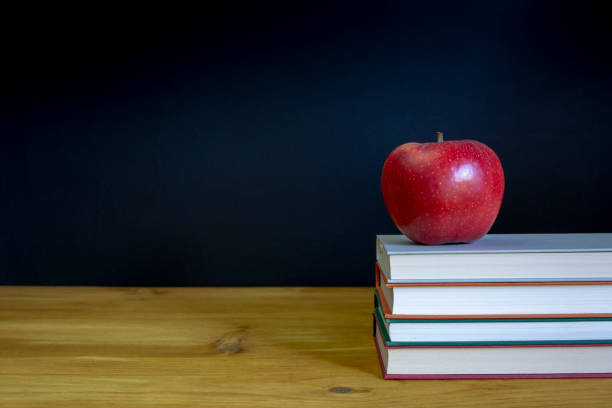 pomme posée sur une pile de livres scolaires