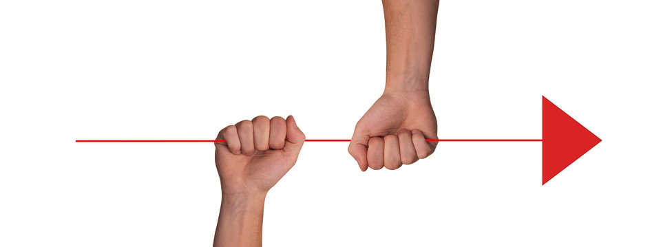 Deux poings serrés tiennent une flèches rouge pointée vers la droite