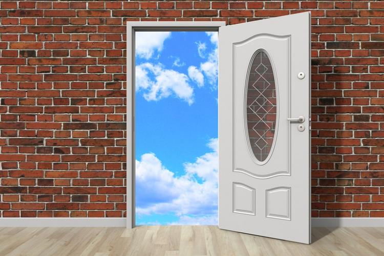 mur de briques avec une porte ouverte sur un beau ciel bleu avec quelques nuages blancs